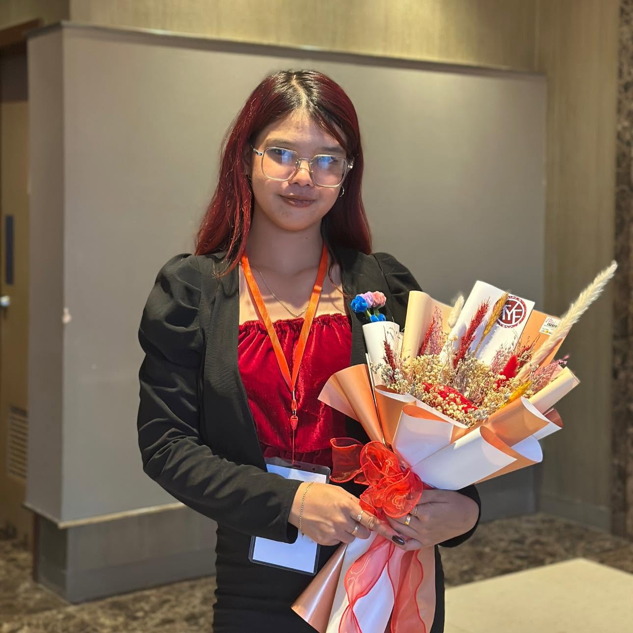 Alyssa with a Fuzzy Fleur by Bia bouquet at a Kapatid Mentor ME event
