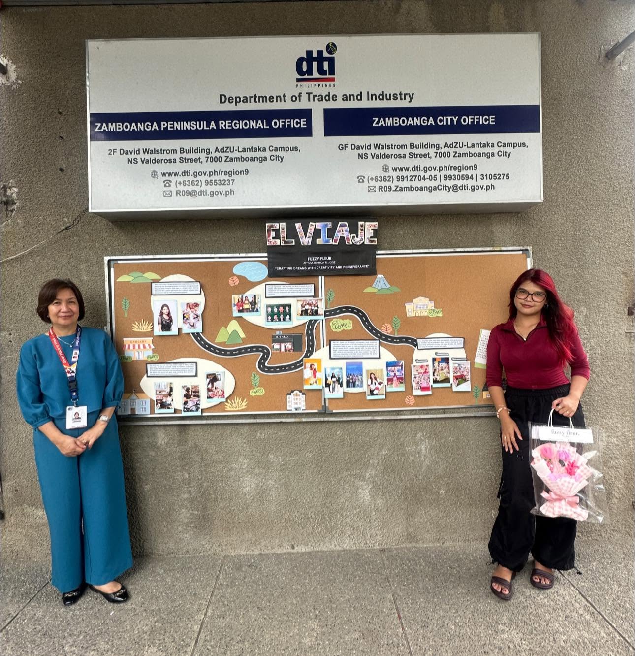 Alyssa Bianca Jose beside the Fuzzy Fleur by Bia story board at the DTI Zamboanga office